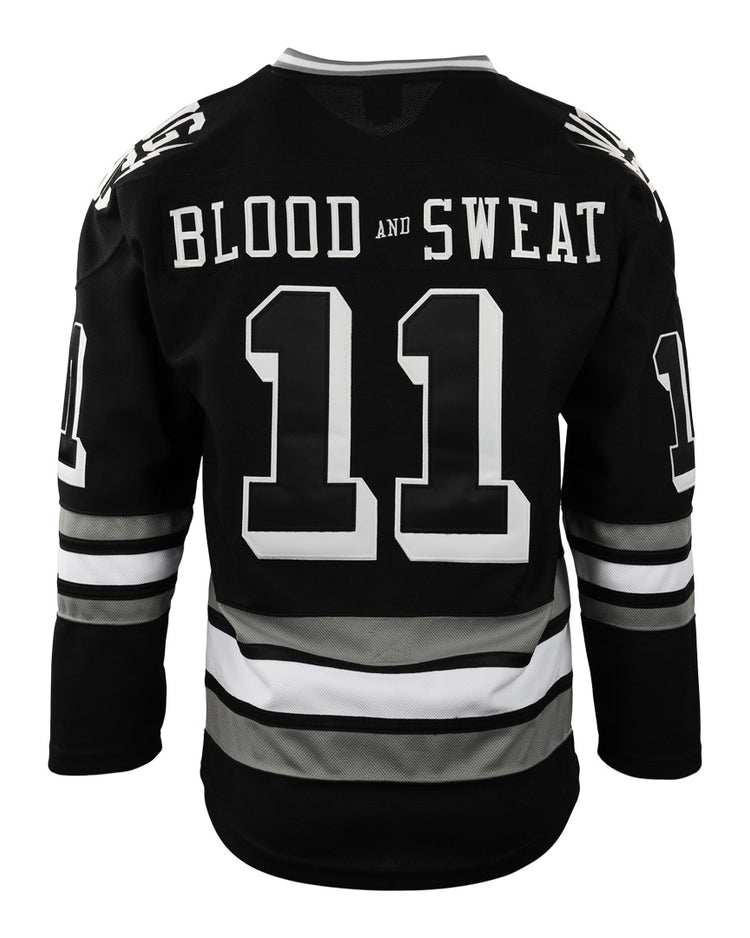The Violent Gentlemen x EFF Collection Hockey Jersey by EFF is a black hockey jersey with white and gray sleeve and waist stripes. BLOOD AND SWEAT is printed above the large number 11 on the back of this bold piece.