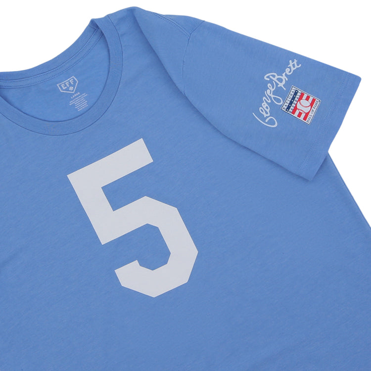 The George Brett Hall of Fame T-Shirt by Ebbets Field Flannels features a light blue design, large white number 5 on the front, and a sleeve patch with red and blue details plus George Brett’s cursive signature.
