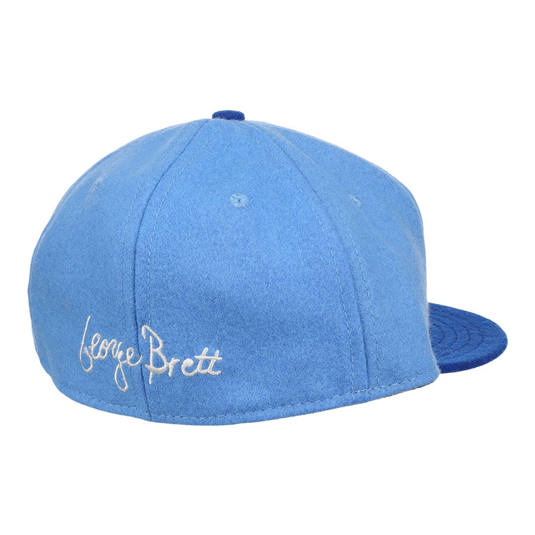 The Ebbets Field Flannels George Brett Signature Series Ballcap features a light blue vintage wool crown, darker blue brim, and white script embroidery of George Brett’s signature—a tribute to the Hall of Fame legend.