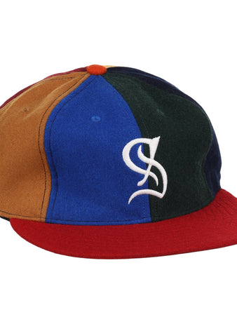 The EFF Santurce Cangrejeros Vintage Inspired Pinwheel Ballcap features brown, blue, green, and navy panels, a red brim, an orange top button, and a white stylized S logo on the front.