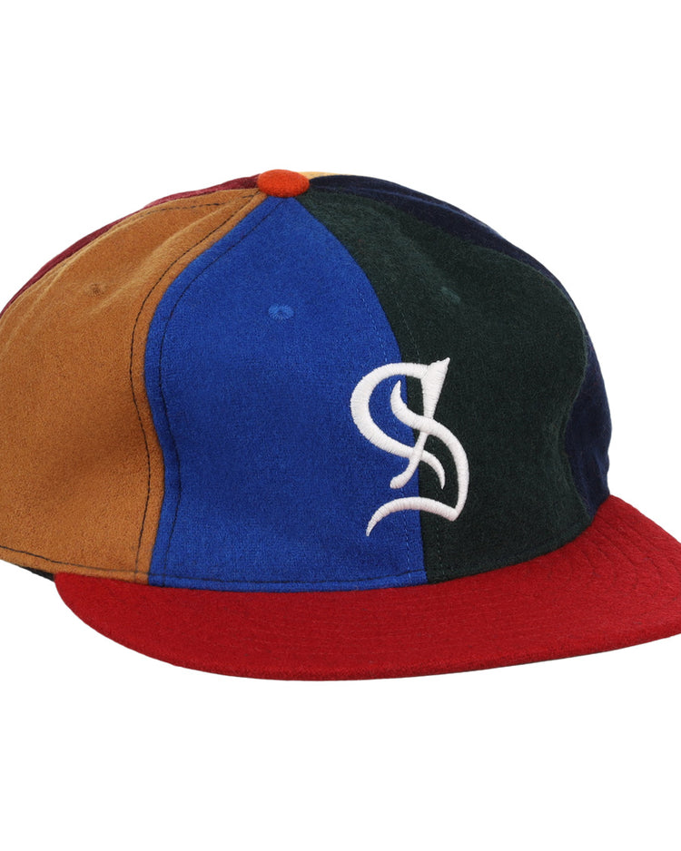 The EFF Santurce Cangrejeros Vintage Inspired Pinwheel Ballcap features brown, blue, green, and navy panels, a red brim, an orange top button, and a white stylized S logo on the front.
