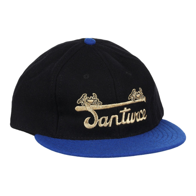 The EFF Santurce Cangrejeros Gilded Collection Ballcap features a black crown, blue brim, gold scroll details, and Santwoz gold script embroidery—a striking nod to the Puerto Rico League.