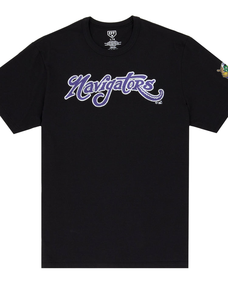 The Norwich Navigators EFF MiLB Vintage T-Shirt by Ebbets Field Flannels is a black tee with Navigators in bold purple and white script across the chest and a small colorful graphic on the left sleeve, inspired by classic Minor League styles.
