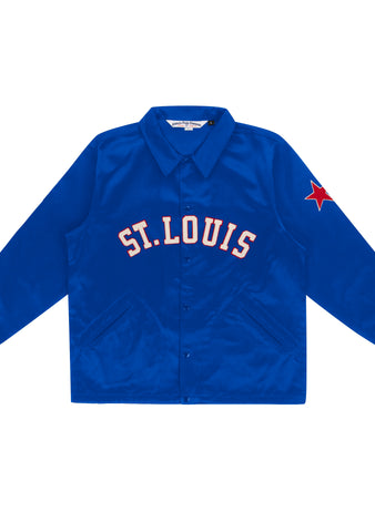 The EFF St. Louis Stars Satin Windbreaker is a bright blue jacket inspired by vintage windbreakers, featuring ST. LOUIS in bold white and red across the chest and a red star patch on the left sleeve.