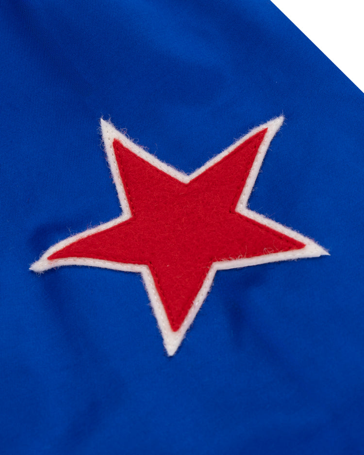 A red star with a white border is sewn onto bright blue satin, evoking vintage style in the EFF St. Louis Stars Satin Windbreaker.