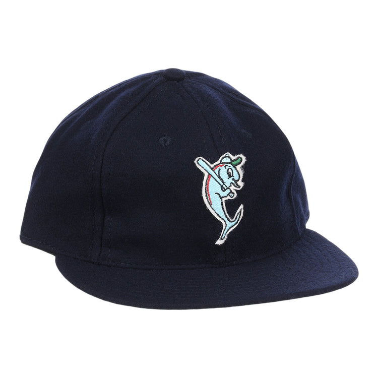 The EFF Tampa Tarpons Letterhead Wool Vintage Ballcap is a navy blue cap with a cartoon dolphin mascot in a green cap and red bat, inspired by Minor League baseball and the playful spirit of the Tampa Tarpons.