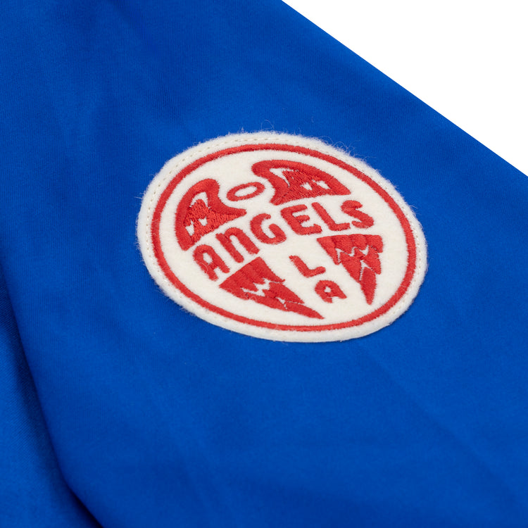 The EFF Los Angeles (PCL) Satin Windbreaker features a round white patch with red “ANGELS LA” lettering and winged design on blue fabric, channeling the classic Pacific Coast League style.