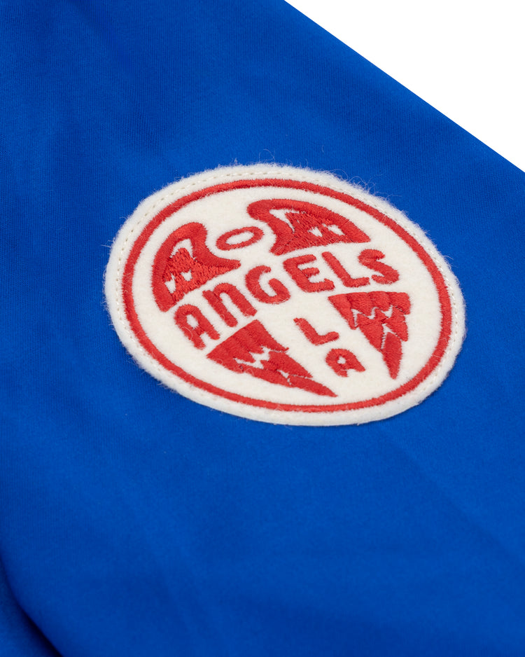 The EFF Los Angeles (PCL) Satin Windbreaker features a round white patch with red “ANGELS LA” lettering and winged design on blue fabric, channeling the classic Pacific Coast League style.