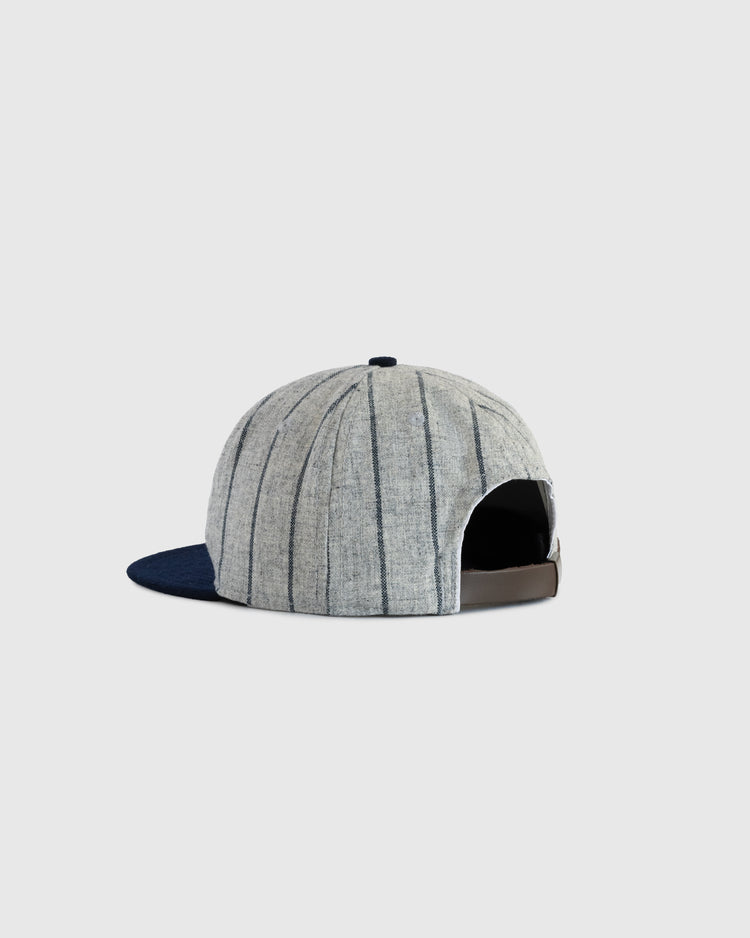The EFF Sacramento Senators Authentic Wool Ballcap is grey with thin stripes and a navy blue brim. Seen from the back, it features an opening, adjustable brown strap, and is set against a plain light grey background.