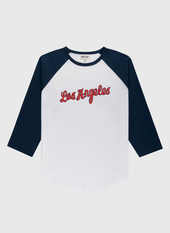 The Ebbets Field Los Angeles Angels (PCL) Vintage Baseball Tee is a white shirt with navy blue three-quarter sleeves and “Los Angeles” in red script, inspired by classic minor league team style, shown on a plain light gray background.