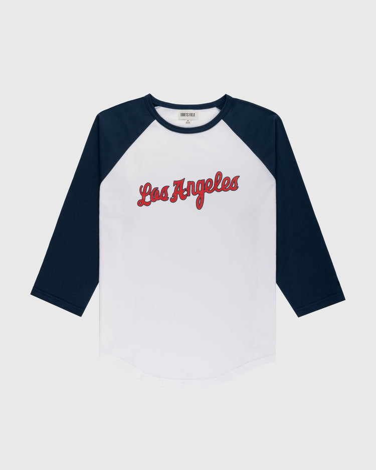The Ebbets Field Los Angeles Angels (PCL) Vintage Baseball Tee is a white shirt with navy blue three-quarter sleeves and “Los Angeles” in red script, inspired by classic minor league team style, shown on a plain light gray background.