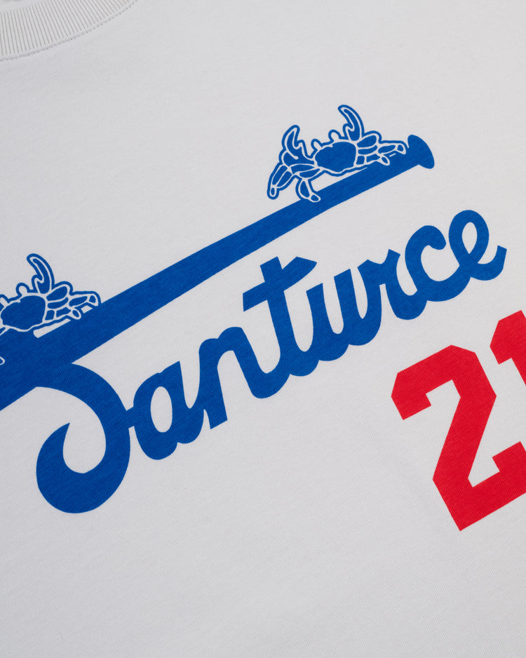 The Ebbets Field Santurce Cangrejeros Short Sleeve Tee features white fabric, “Santurce” in blue cursive, two blue crabs above, and a bold red 21—a nod to Santurce baseball history and Roberto Clemente.