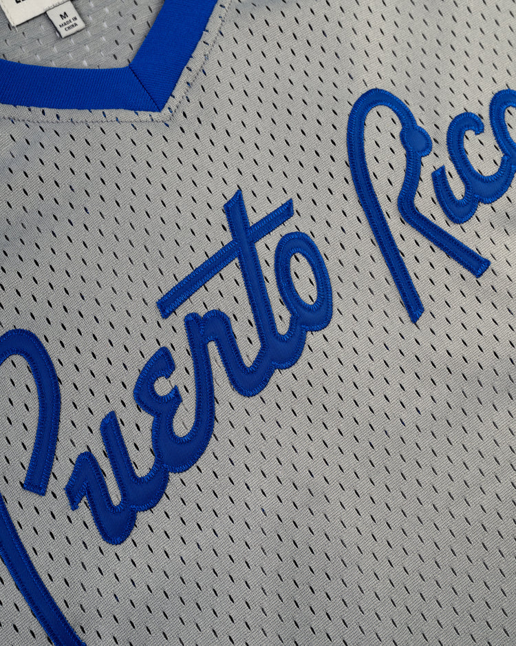 Close-up of the Puerto Rico 1958 National Team Mesh V-Neck Jersey by Ebbets Field, featuring gray mesh fabric for breathability, blue trim, and Puerto Rico in blue script across the front, inspired by classic Puerto Rican baseball jerseys.
