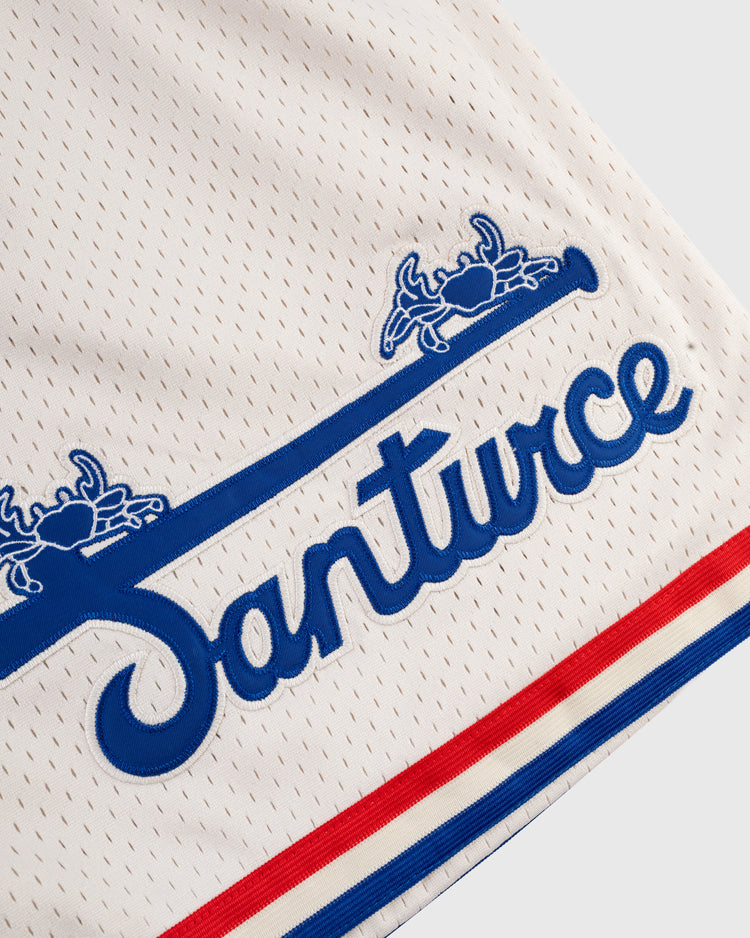 Close-up of Ebbets Fields Santurce Cangrejeros Mesh Shorts, featuring Santurce in blue script, blue crab and bat graphics, plus red and blue stripes—celebrating Puerto Rican baseball spirit.