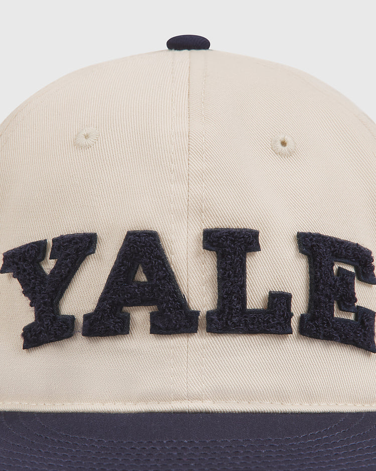 A close-up of the Yale Chenille Logo Cotton Twill Ballcap by Ebbets Field, featuring large, textured navy blue “YALE” lettering on the front for a classic Ivy League look.