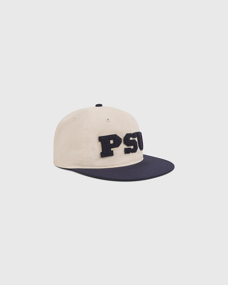 The Ebbets Field Penn State Chenille Logo Cotton Twill Ballcap, featuring bold chenille PSU lettering on a beige and navy design, rests on a light gray background—making it the ideal ballcap for any Penn State fan.
