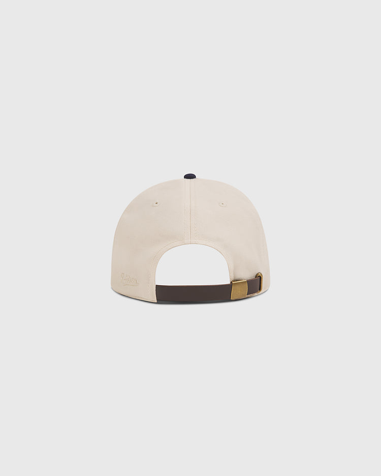 The Penn State Chenille Logo Cotton Twill Ballcap by Ebbets Field is displayed from the back, highlighting its adjustable strap with a brass buckle and a dark brown trim along the base. The plain, light-colored background keeps the focus on the cap.
