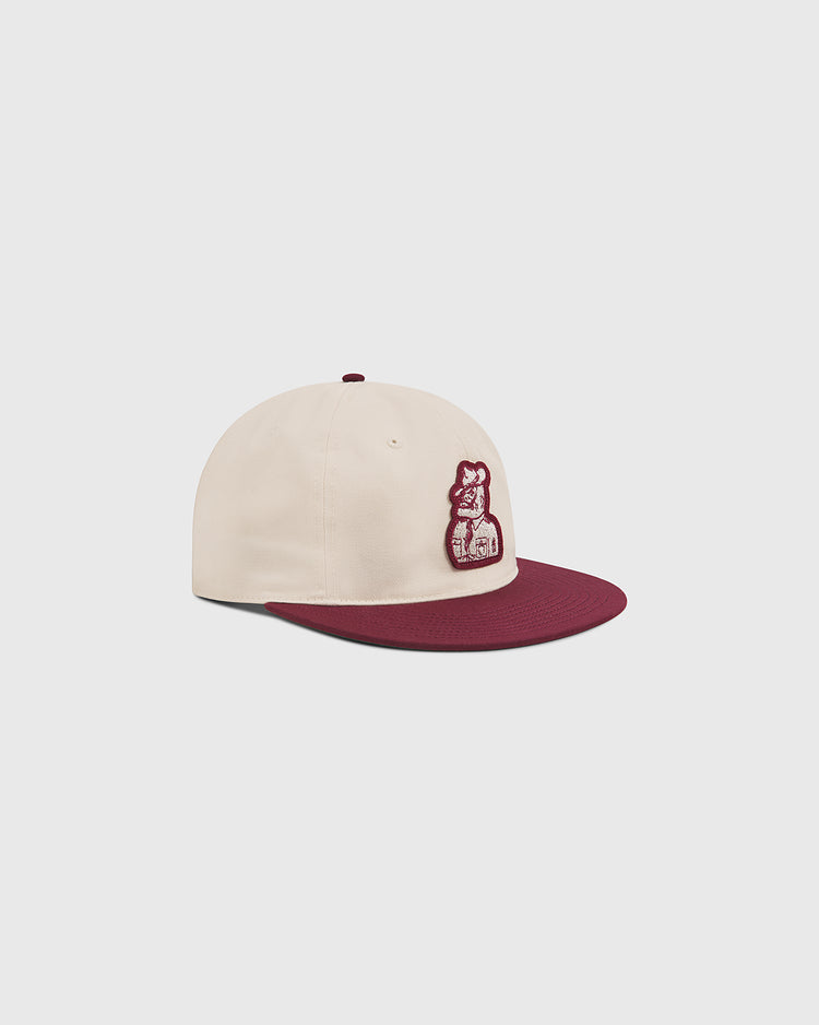 Show your Texas A&M University pride with the Ebbets Field Texas A&M Sarge Cotton Twill Ballcap—featuring a cream-colored cotton twill body, maroon brim, and a maroon embroidered bear logo on the front. Displayed on a plain light grey background.