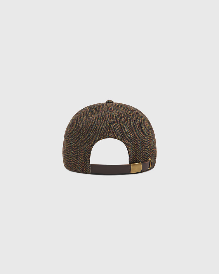 The Ebbets Field Harvard University Herringbone Ballcap, shown from the back against a plain light gray background, features a brown fabric herringbone pattern, a curved brim, and an adjustable leather strap with a brass buckle.
