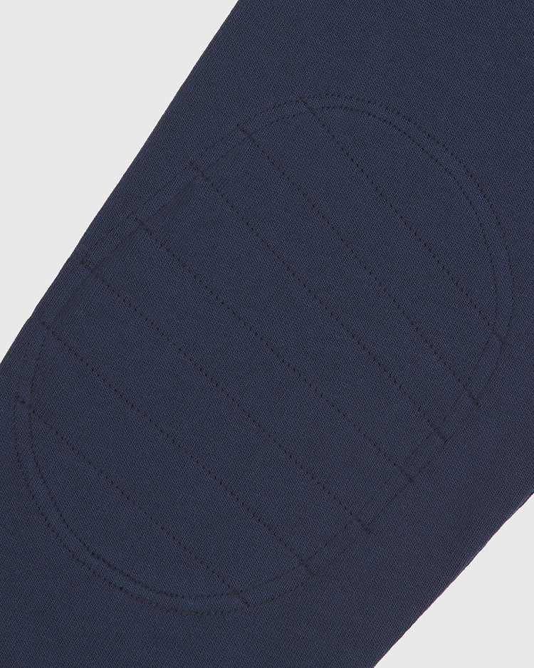 Close-up of a navy blue fabric from the Ebbets Field Notre Dame X Guinness Rugby Shirt, showcasing an oval-shaped, stitched elbow patch with horizontal seam lines for added reinforcement—blending classic style with proud Irish heritage.