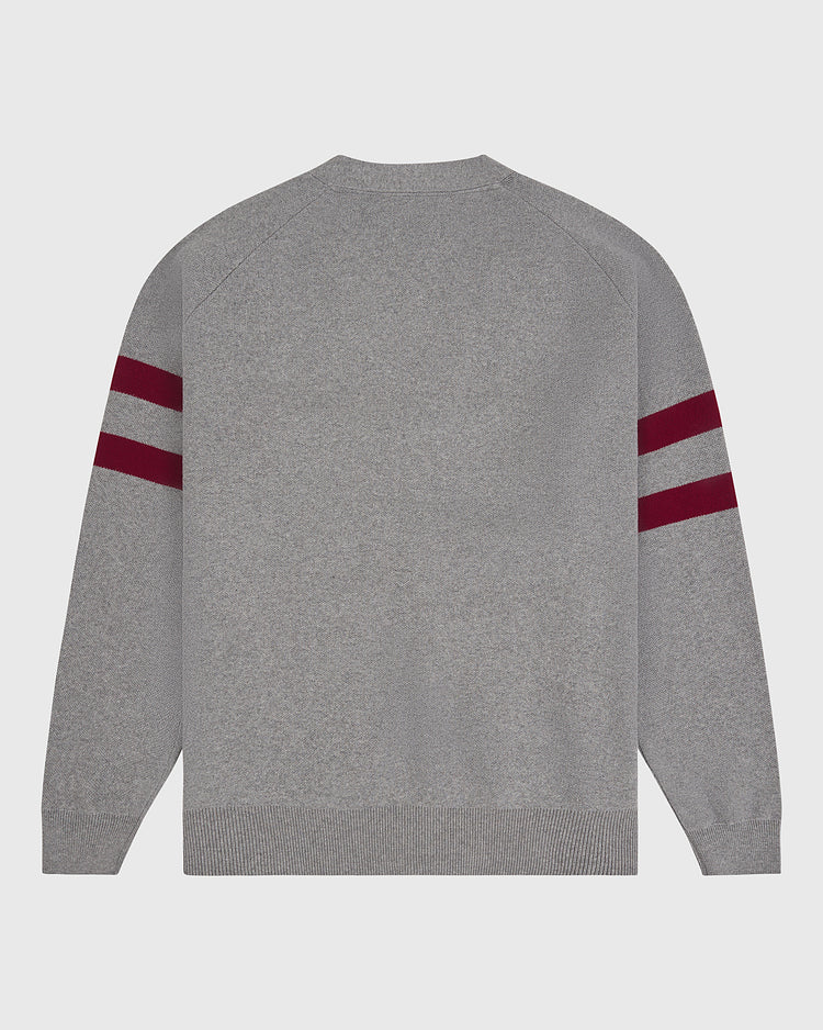 The Harvard University Cotton Varsity Cardigan by Ebbets Field is shown laid flat with the back facing up against a white background, featuring a gray knit design with long sleeves and two maroon stripes on each upper arm.