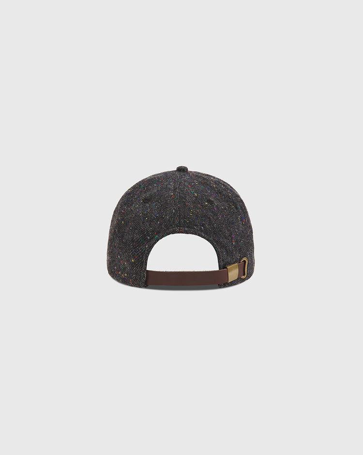The Notre Dame X Magee Irish Donegal Wool Ballcap by Ebbets Field is shown from the back, displaying its dark speckled wool fabric and brown adjustable leather strap with a brass buckle, set against a plain light background.