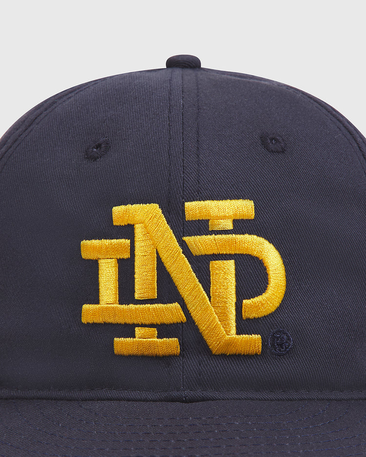 An Ebbets Field Notre Dame Cotton Ballcap in navy blue, featuring an interlocking gold ND embroidered on the front.