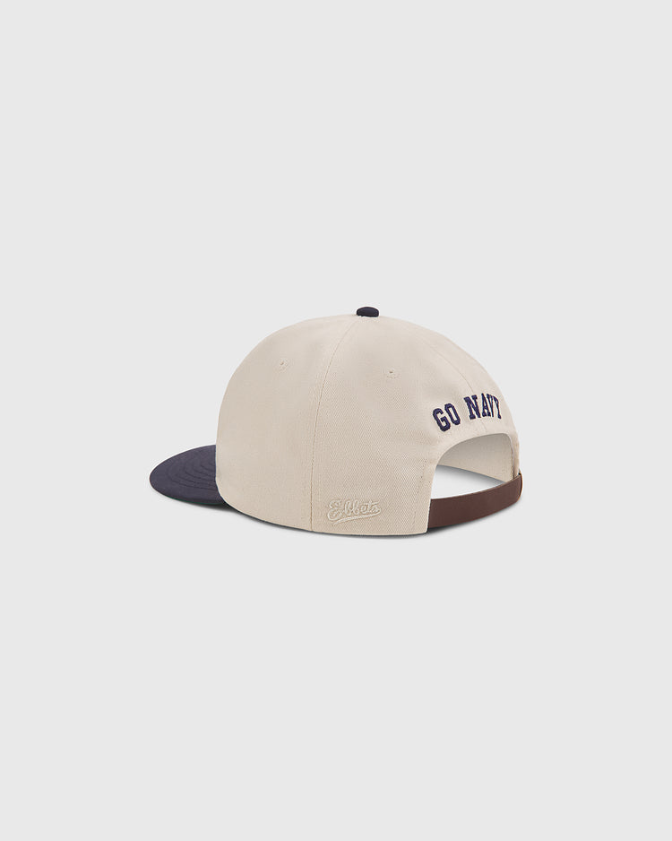 The Ebbets Field Navy 1958 Logo Cotton Twill Ballcap is pictured from the back in beige and navy blue, with “GO NAVY” embroidered above the adjustable strap. The brim is navy, and “Ebbets Field” is stitched in white on the left side.