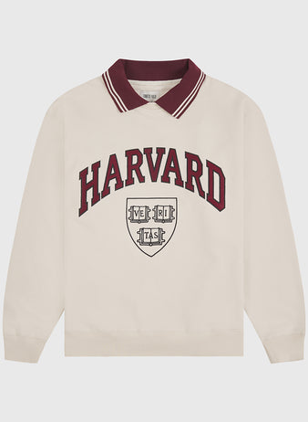 Ebbets Field’s Harvard University Collared Crewneck Sweatshirt is a beige long-sleeve top featuring a maroon collar with two thin white stripes and “HARVARD” in maroon text above the university shield printed in maroon and black.