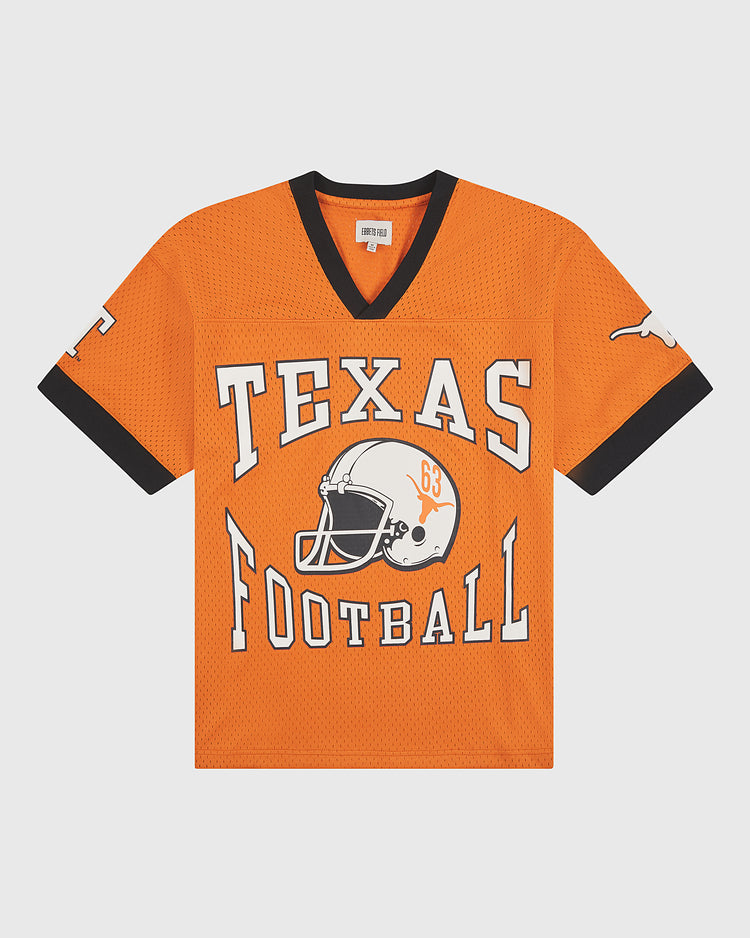 The Ebbets Field University of Texas Mesh Football Jersey features bold black trim, a white football helmet graphic, and “TEXAS FOOTBALL” in prominent lettering across the front. A classic white longhorn adorns the sleeve, capturing timeless University of Texas style inspired by vintage Longhorn jerseys.