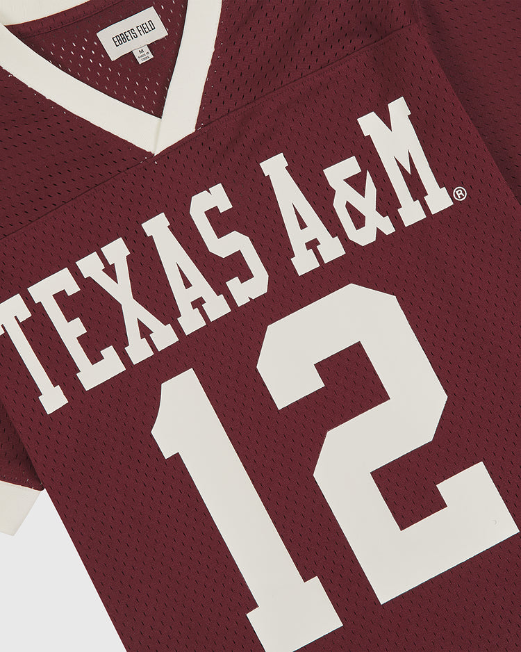 Show your Aggie pride with the Ebbets Field Texas A&M Mesh Football Jersey. This vintage-inspired jersey showcases a classic maroon mesh design, bold white TEXAS A&M lettering, and the number 12 on the front. Crafted for comfort with breathable mesh material and a crisp white collar, it’s an ideal choice for any Texas A&M Aggies fan looking for authentic game-day style.