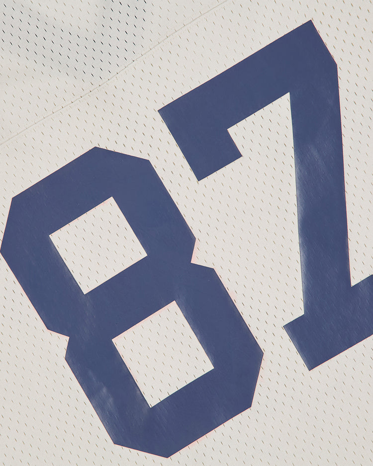 Close-up of an Ebbets Field Penn State University Mesh Football Jersey, showcasing a large blue number 87 on a white background. The vintage-inspired mesh jersey features a textured design for enhanced breathability.