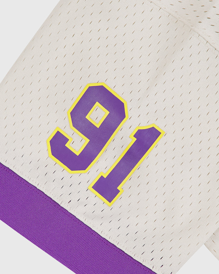 The Ebbets Field University of Washington Mesh Football Jersey features a white perforated fabric for breathability, with striking purple and yellow number 91 on the sleeve. A purple cuff adds a classic Huskies touch, making this jersey perfect for showing your UW pride at the next Rose Bowl.