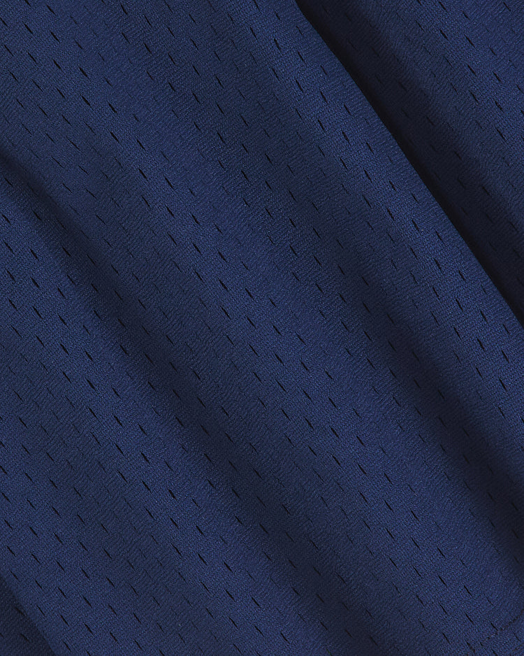 Close-up of dark blue, breathable mesh fabric from the Ebbets Field Yale Mesh Football Jersey, featuring small, evenly spaced holes and visible texture with soft folds and shadows—evoking the look of a vintage Yale Bulldogs or classic Yale football jersey.