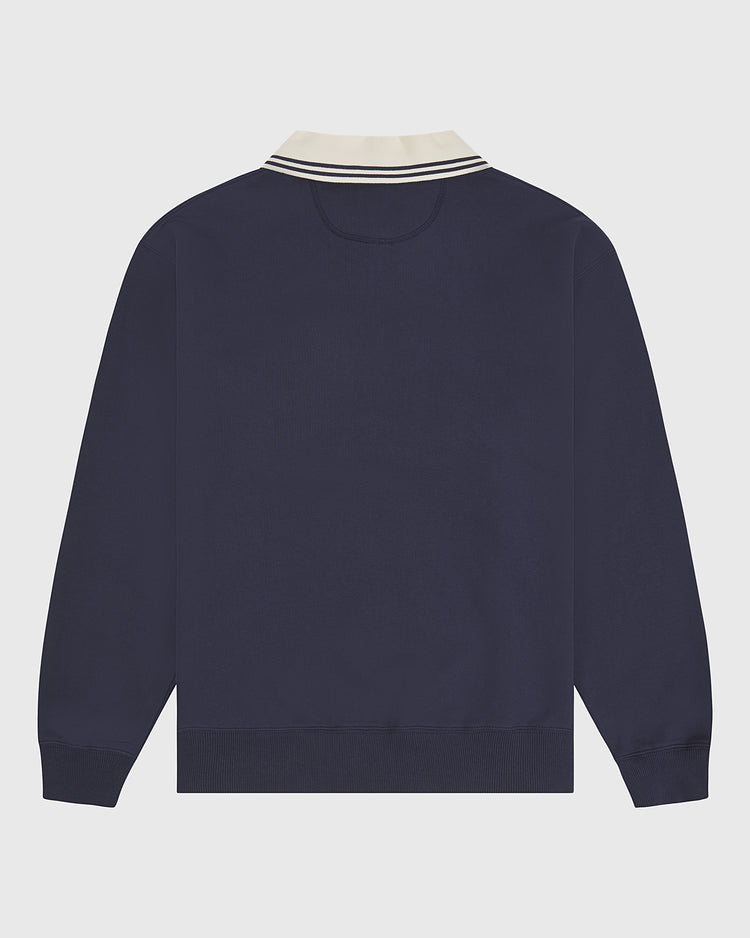 Ebbets Field University of Connecticut Collared Crewneck shown from the back features a navy blue long-sleeve design with a ribbed hem and cuffs, and a white collar accented by two navy blue stripes. The background is light gray.