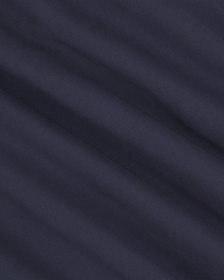Close-up of the Ebbets Field University of Connecticut Collared Crewneck in dark navy blue, showcasing its subtle diagonal ribbed texture and gentle fold lines across the fabric.