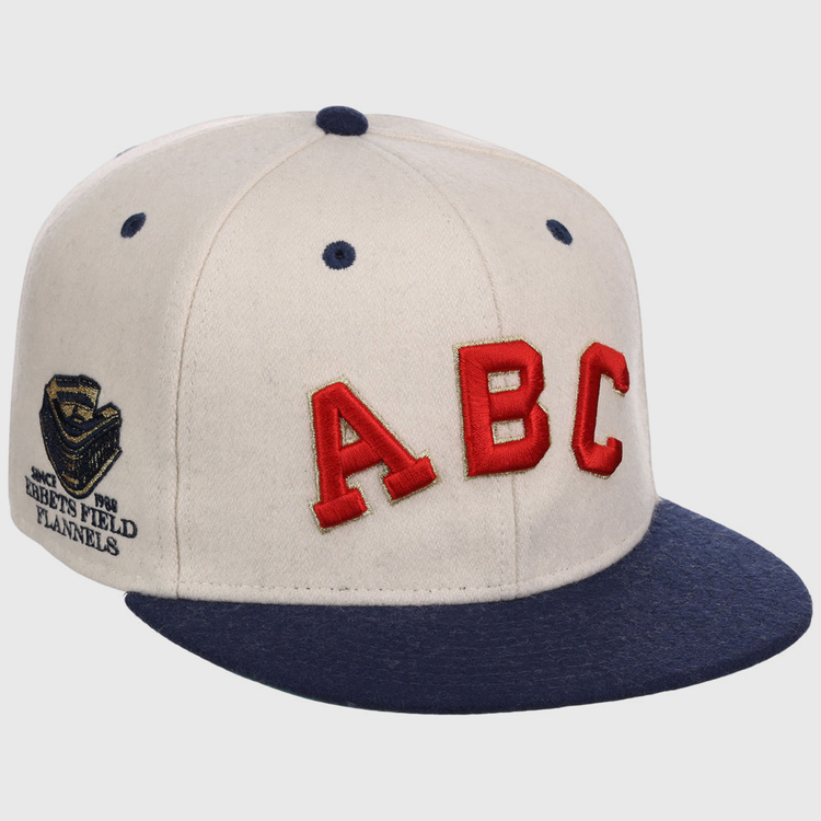 The Atlanta Black Crackers NLB Ballpark Fitted Ballcap by Ebbets Field features a cream crown, navy brim and button, bold red ABC letters on the front, and a gold 
