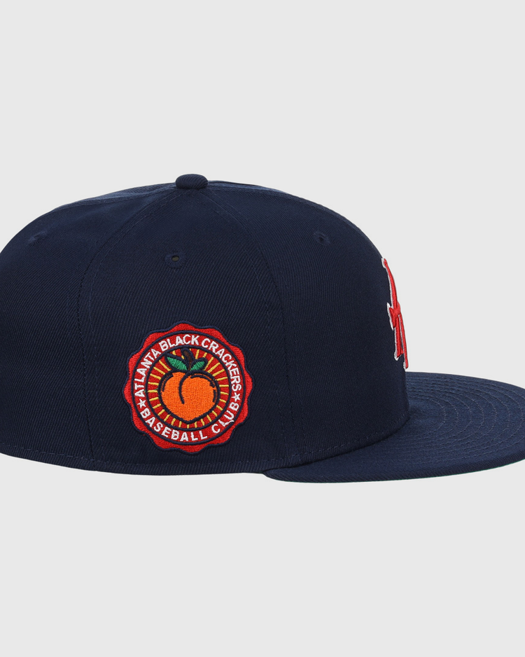 The EFF Atlanta Black Crackers NLB Team Color Fitted Ballcap in navy features a red and orange side patch reading Atlanta Black Crackers Baseball Club around an orange baseball, inspired by classic Negro Southern League styles.