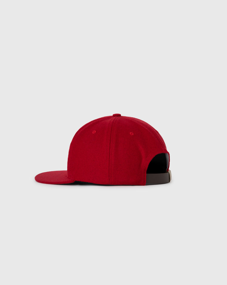 The EFF Aloha 100th Infantry 1942 Authentic Wool Ballcap is shown from the side and back with a flat brim, an adjustable black strap, and a red wool finish, honoring Japanese-American history against a plain light gray background.