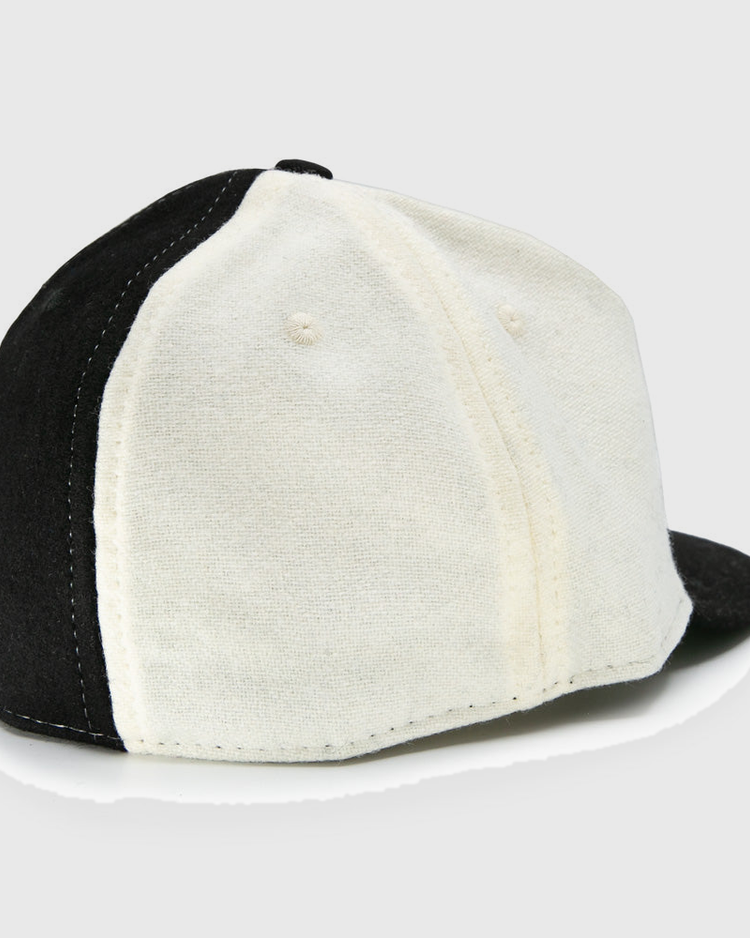 The EFF Bacharach Giants 1924 Vintage Ballcap, crafted from genuine wool, features black and white panels, visible stitching, ventilation holes, and is shown from the back-left side.