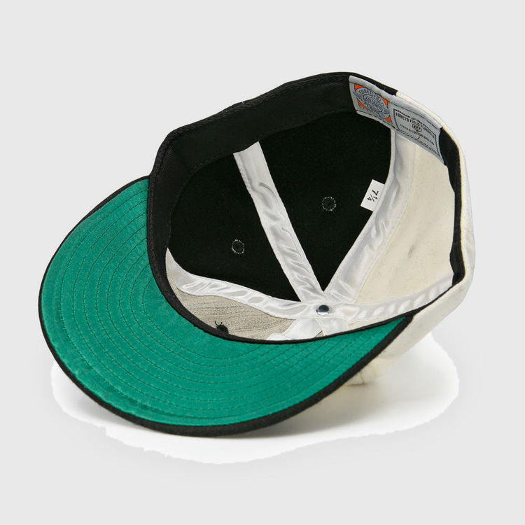 The image shows the inside of an EFF Bacharach Giants 1924 Vintage Ballcap, featuring a green brim, white interior panels, black lining, visible stitching, and a size tag.
