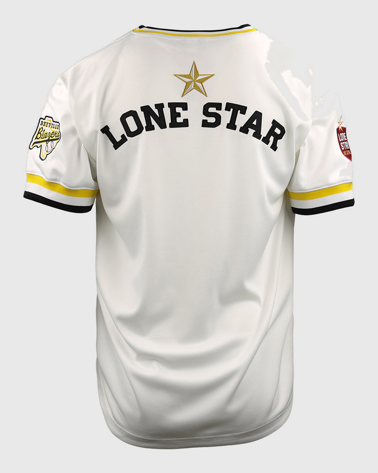 The EFF Beeville Blazers Lone Star Baseball Jersey is white with yellow and black trim, LONE STAR in bold black letters, a gold star on the back, and sleeve patches inspired by Joe Hunter Field in Corpus Christi.