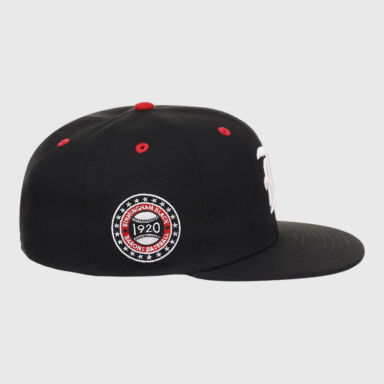 The EFF Birmingham Black Barons NLB Flip Fitted Ballcap is a black hat with a flat brim, red top button, red stitched air holes, and a circular Birmingham Black Barons 1920 patch honoring the Negro National League.