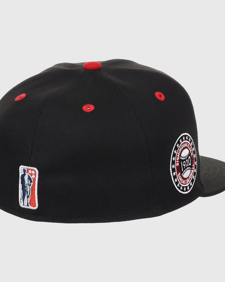 The EFF Birmingham Black Barons NLB Flip Fitted Ballcap features black fabric, red stitching, a side patch embroidered with 1920, and a small red, white, and blue batter logo on the back—honoring the Negro National Leagues legacy.