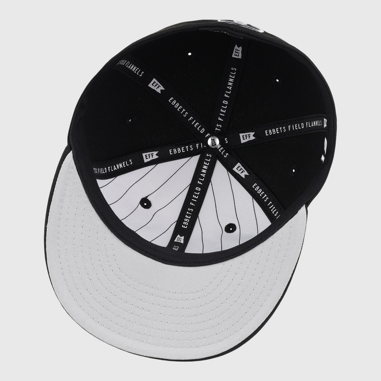 The underside of the Black Fives Fitted Ballcap by Ebbets Field Flannels features a black interior with branded fabric strips and a white brim with black pinstripes, inspired by Black Fives heritage.