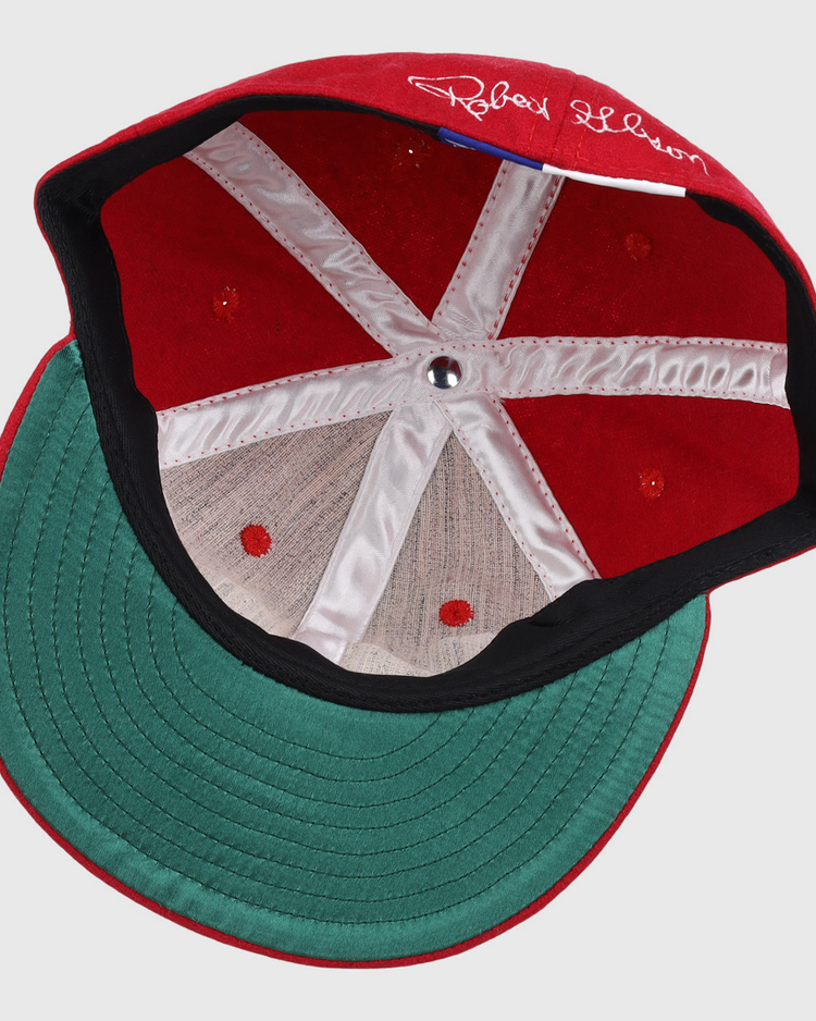 The Bob Gibson Signature Series Ballcap by Ebbets Field Flannels features vintage wool, a green brim, white inner stitching, center metallic button, and a white signature on the inner red section above the brim.