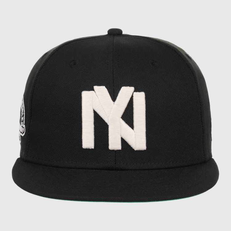 The Ebbets Field Brooklyn Eagles NLB Fitted Ballcap is a black cap with a flat brim, featuring a large white embroidered Brooklyn Eagles logo on the front.