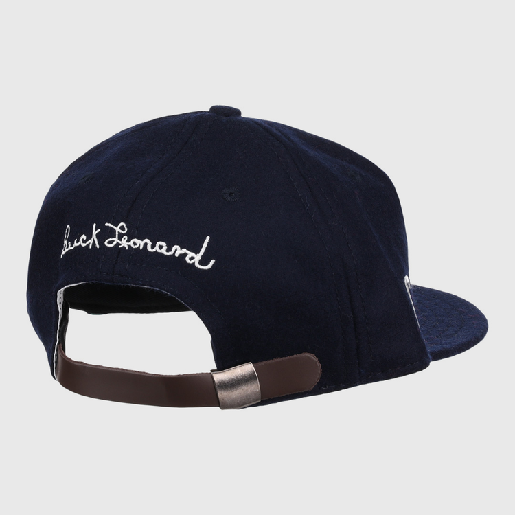 The Buck Leonard Signature Series Ballcap by Ebbets Field Flannels is a navy vintage wool cap seen from the back, with white cursive Buck Leonard embroidery and an adjustable brown strap with metal clasp honoring the Negro Leagues legend.