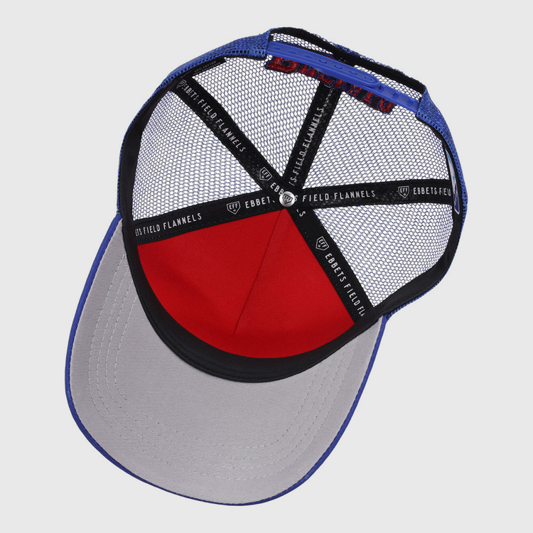The Buffalo Bisons MiLB Trucker Ballcap by Ebbets Field features a blue crown, grey brim, red front panel, black mesh back, and interior seams lined with Ebbets Field branded tape.