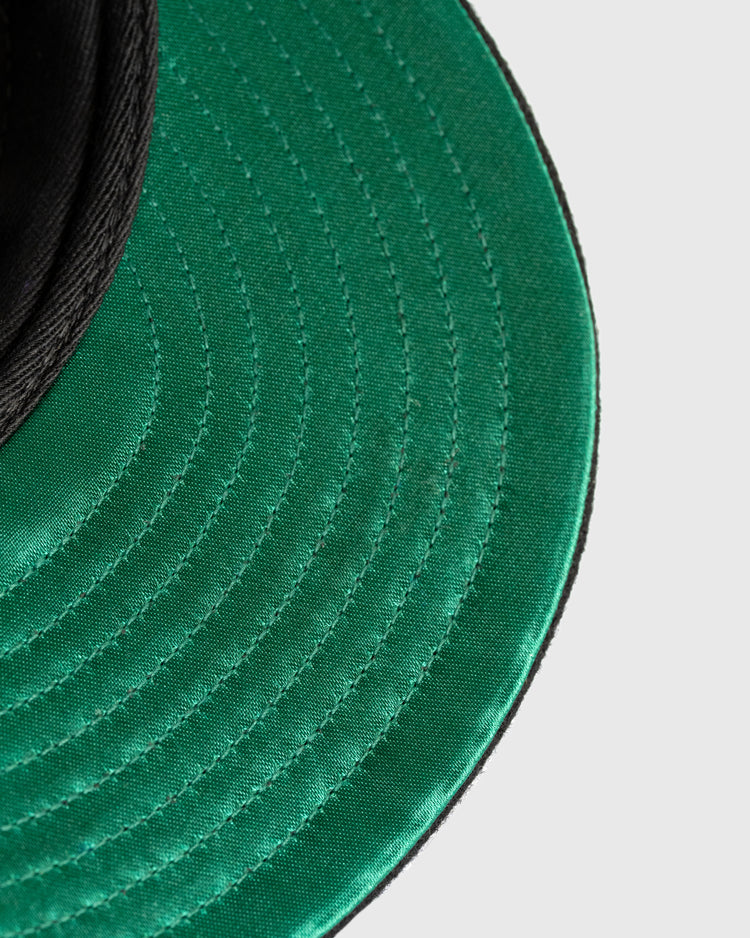 Close-up of the green brim with detailed stitching on an EFF Tokyo Kyojin (Giants) City Series Wool Ballcap, set against a light gray background. The black crown is partially visible at the upper left.
